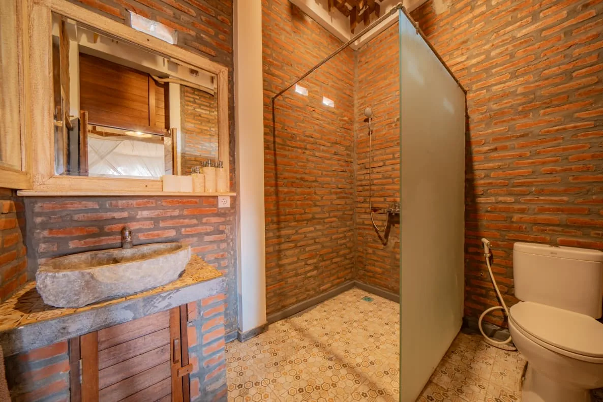 Salle de bain en brique avec douche à effet pluie
